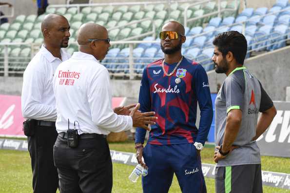 The umpires in discussion with the captains of both teams The umpires in discussion with the captains of both teams